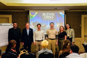 Organizadores e palestrantes posam em frente ao telão do Brazilian Summit Day — Turnê Buenos Aires 2026