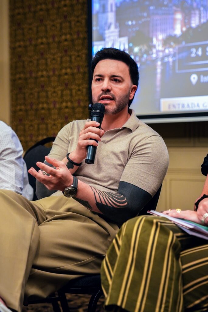 Painelista gesticula enquanto fala ao microfone no Brazilian Summit Day — Turnê Buenos Aires 2026