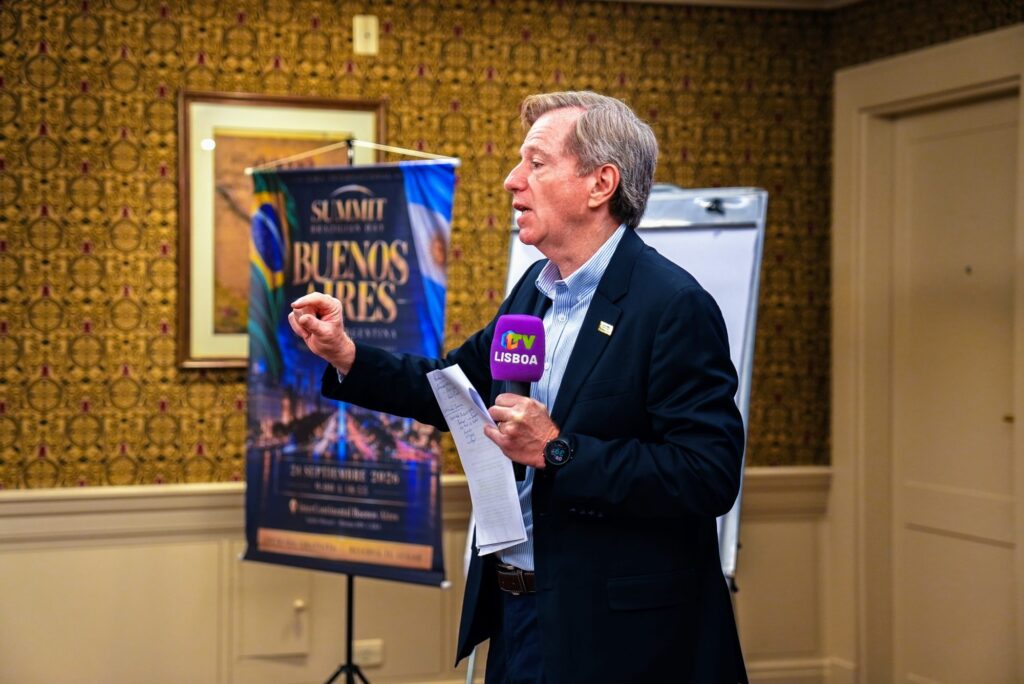 Palestrante fala ao microfone diante do banner do Summit no Brazilian Summit Day — Turnê Buenos Aires 2026